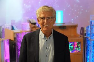 Directeur van Barry Emons, Ruud van Nieuwenburg, portretfoto met op de achtergrond mobiele snoezelkarren.