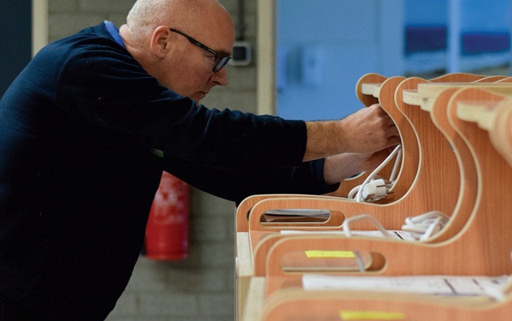 Een werknemer van Barry Emons monteert snoezelkarren.